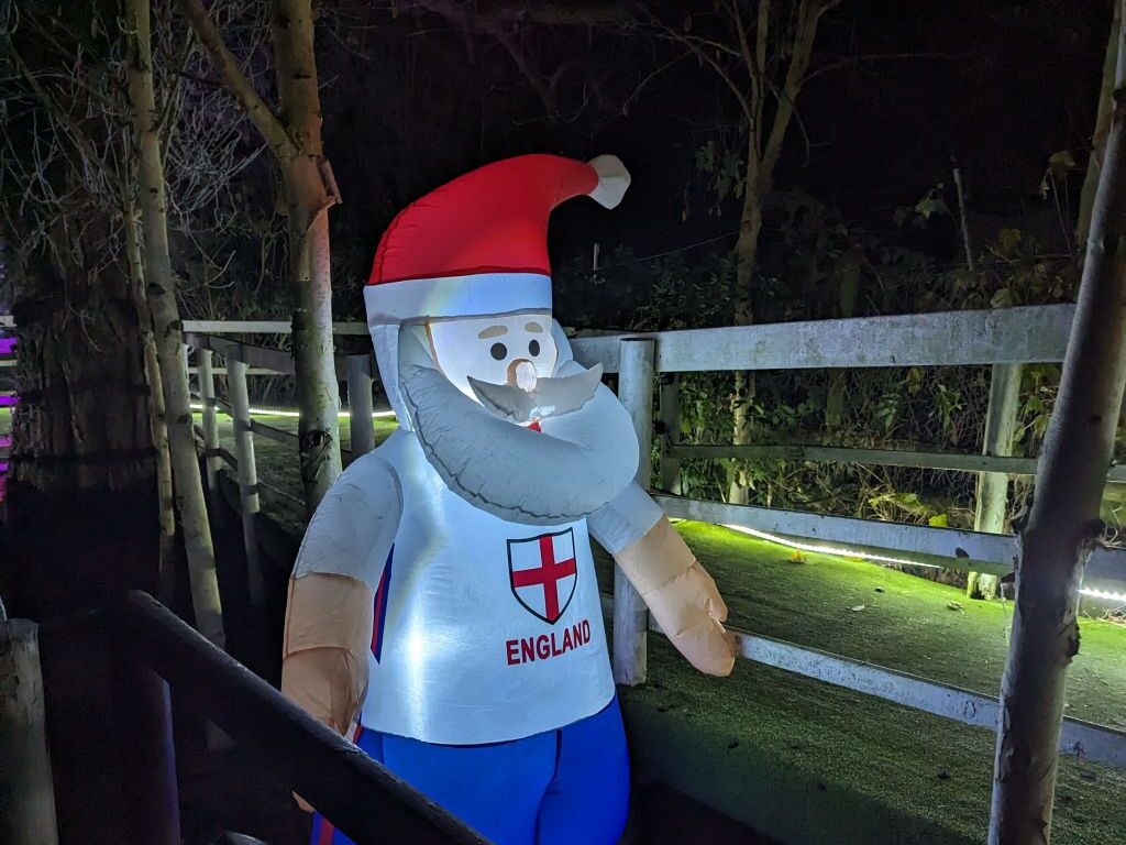 An inflatable Santa wearing a white vest with the English Flag across it.