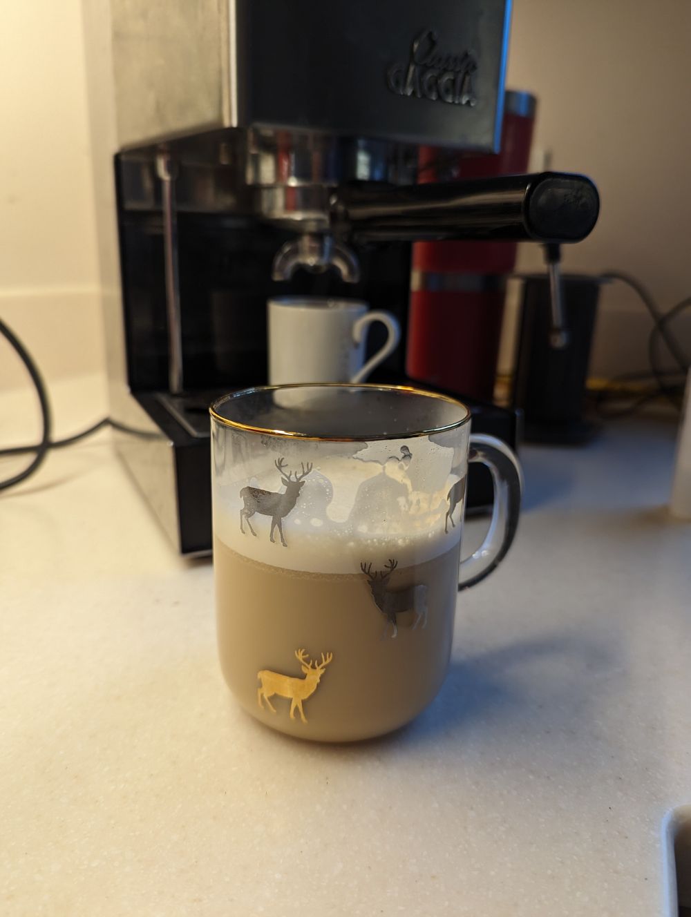 An Irish coffee in a festive mug in front of a gaggia coffee machine