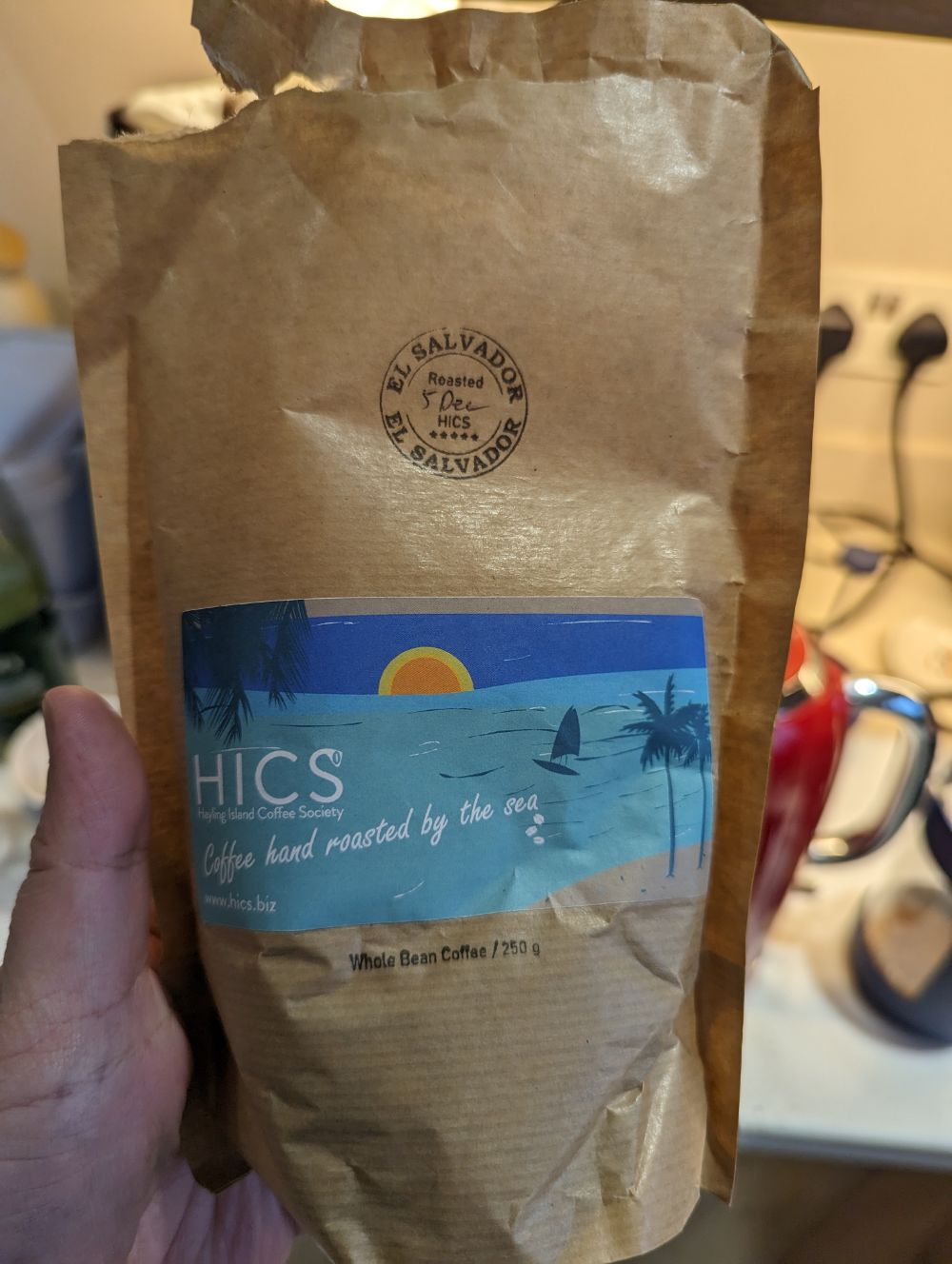 a bag of coffee in a person's hand