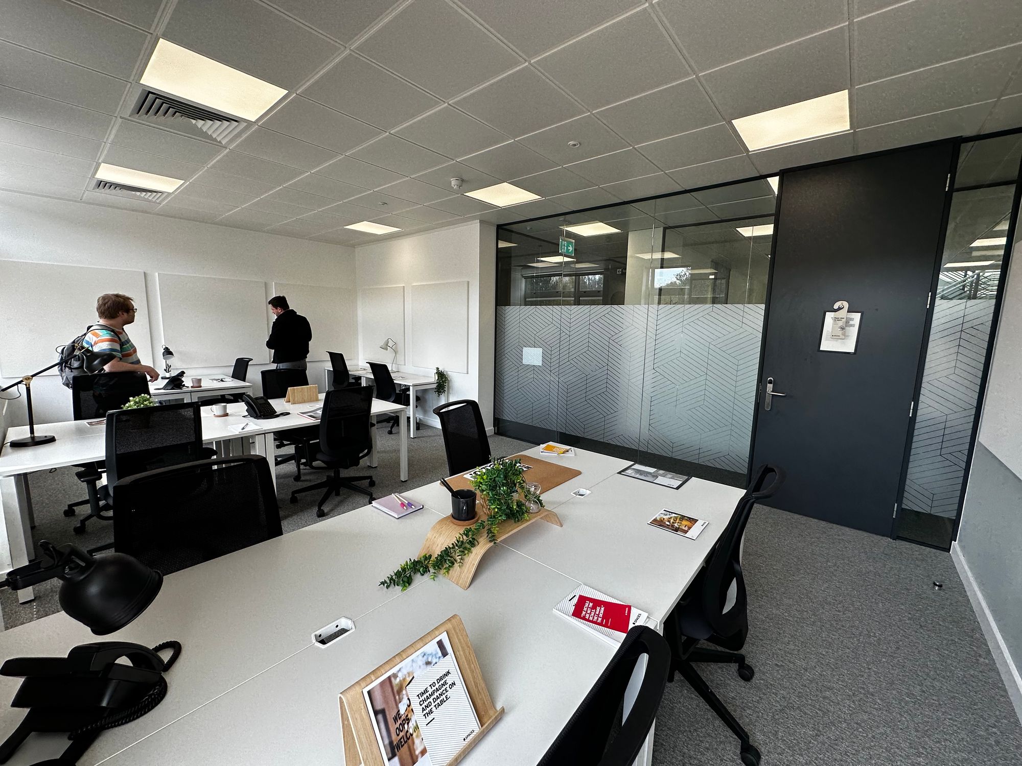 James standing with his back to the camera in a light breezy office space