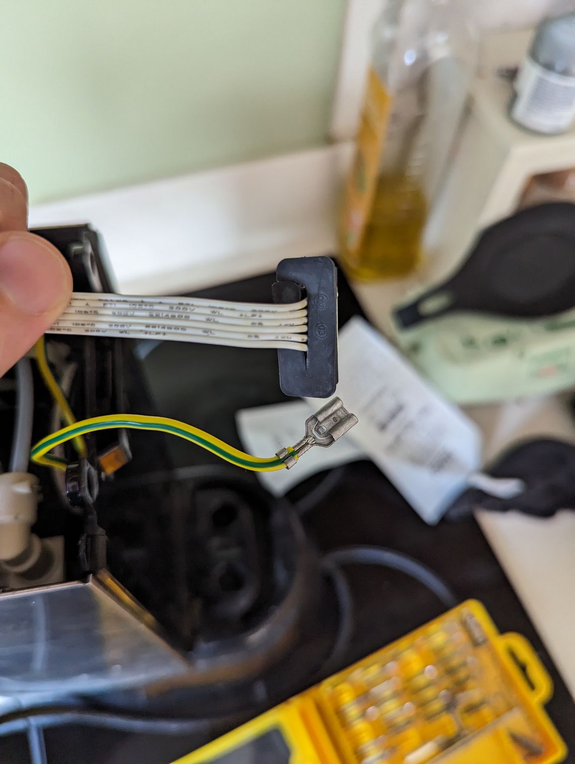 some electrical components in the foreground and a blurry coffee machine in the background