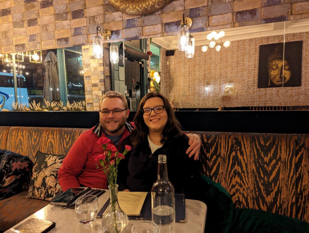 James and Mrs R sat in Nok's Kitchen in Edinburgh with a bottle of water in front of them on the table.