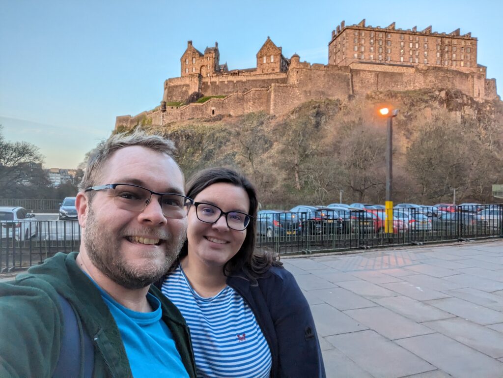 James and Mrs R posing in front of Edinburgh Castle on a sunny afternoon.