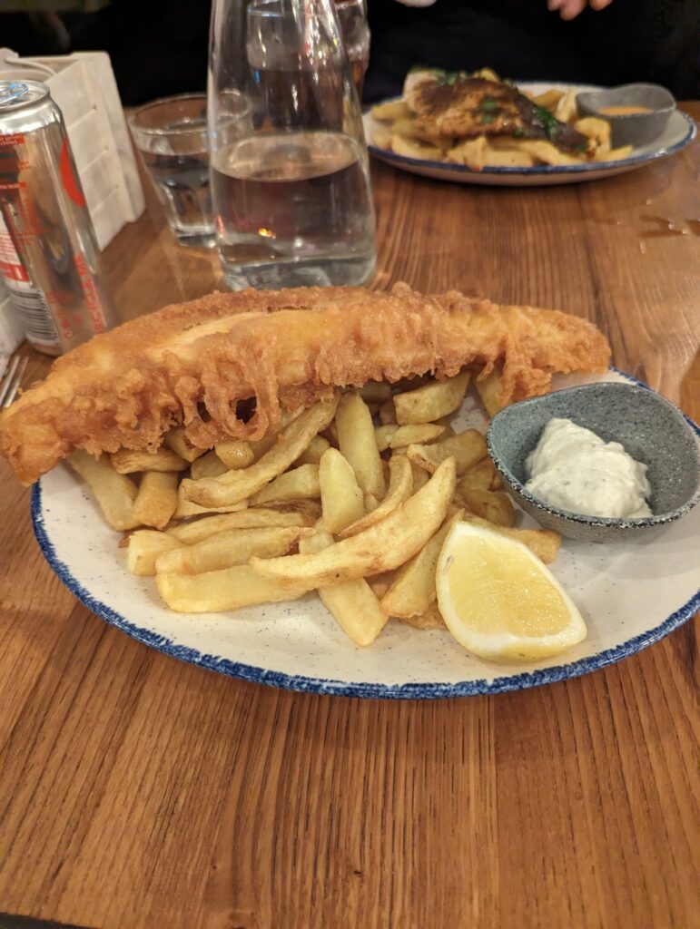 A monster plate of fish and chips with a wedge of lemon and tartar sauce