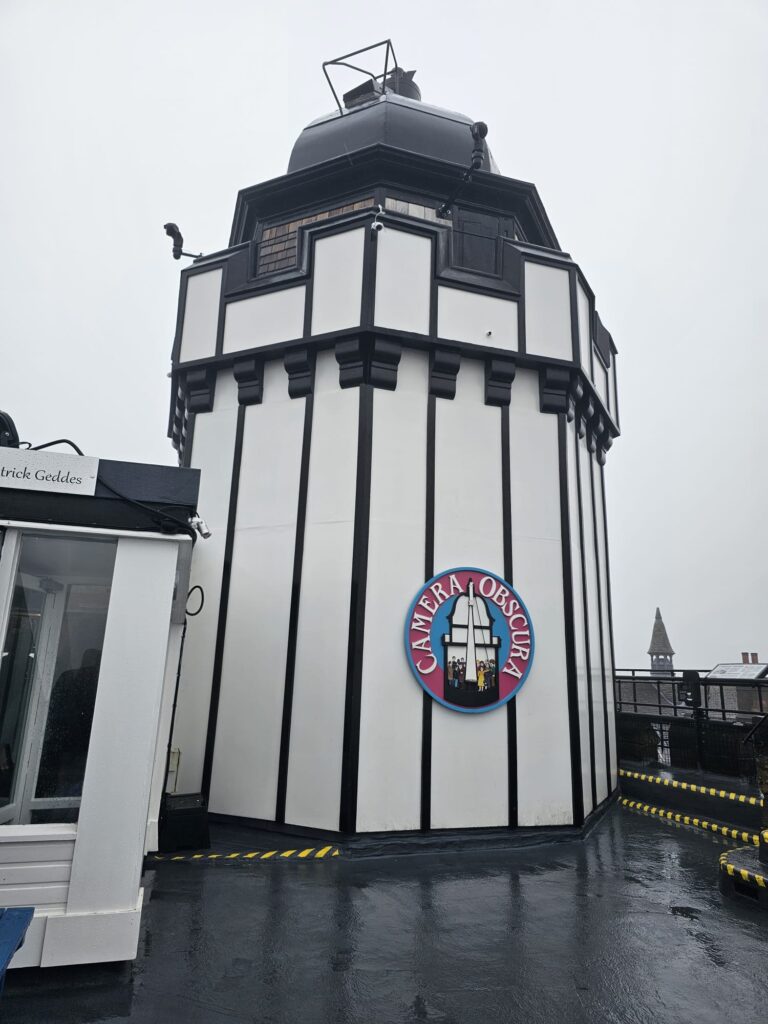 An external shot of the camera obscura on a rainy day. It's a round tower with a hole at the top to let light in.