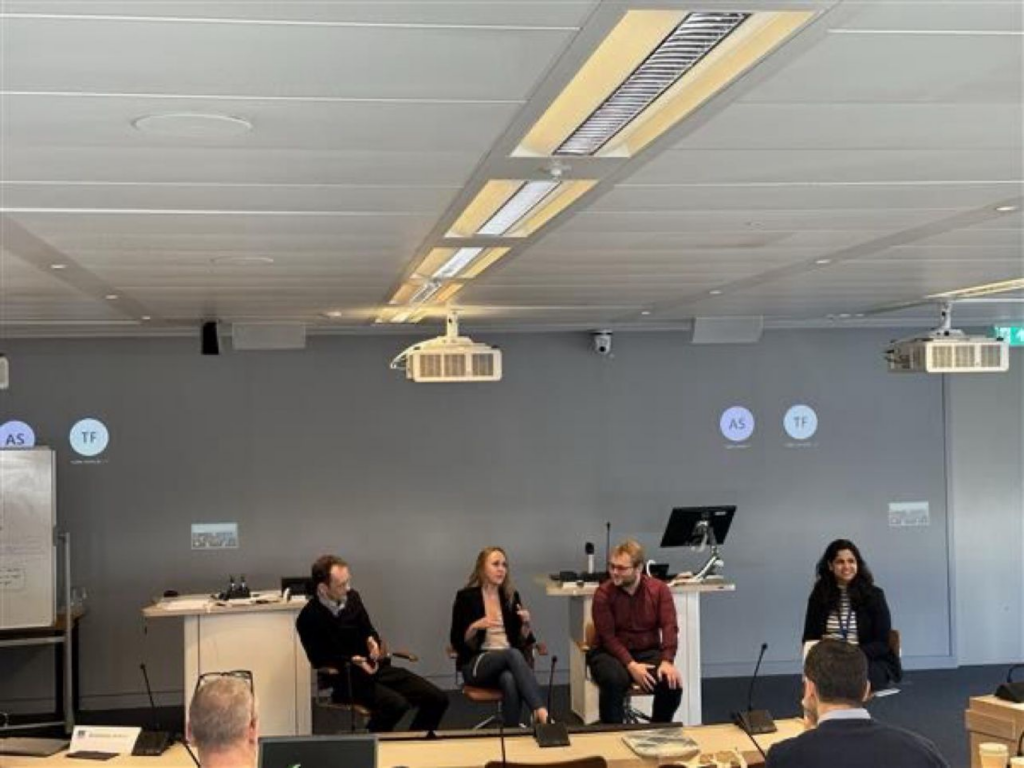 A webcam photo of panelists sat in a lecture theatre with James in the middle.